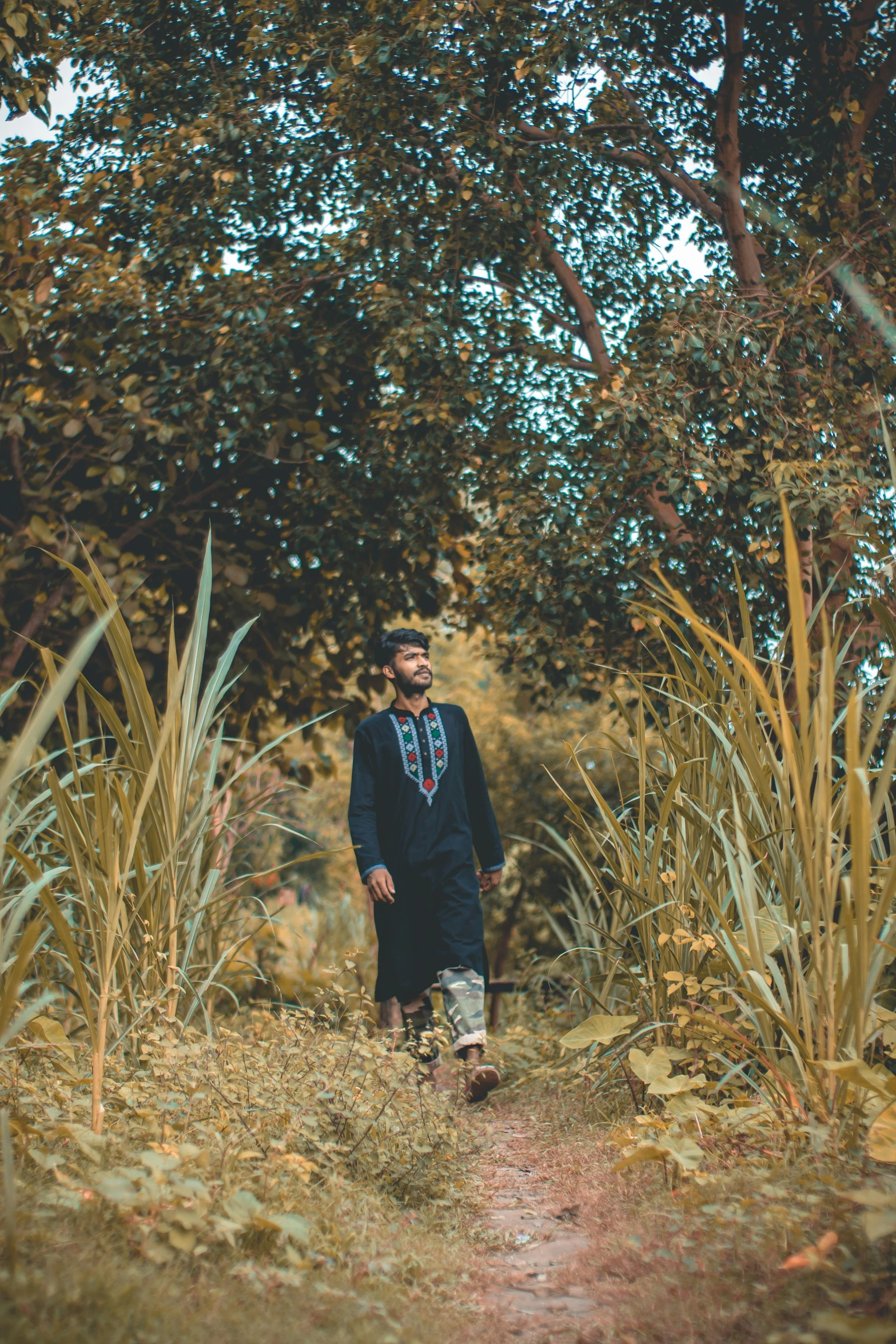 a young man in a black robe and tie is walking