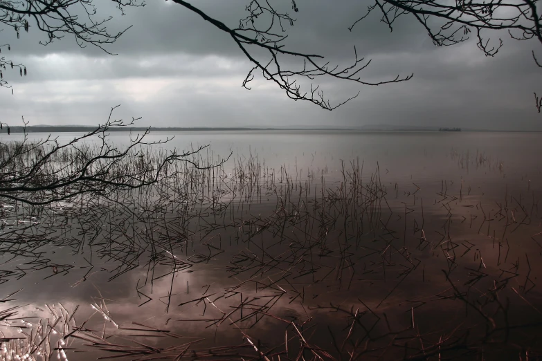 a dark sky is seen over a calm lake