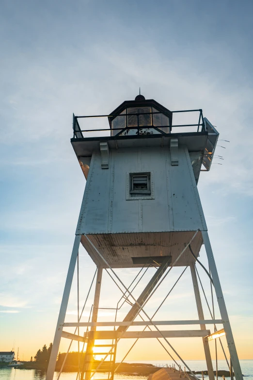 a large water tower with a sunset in the background