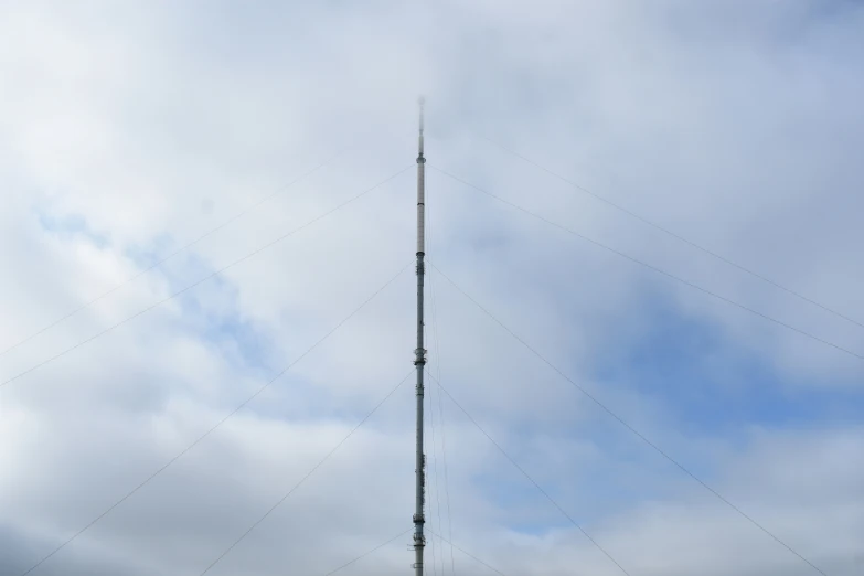 a very tall antenna structure sitting on top of a lush green field