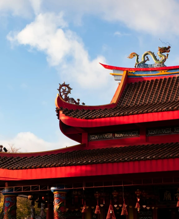 red and gold building with statue atop the top