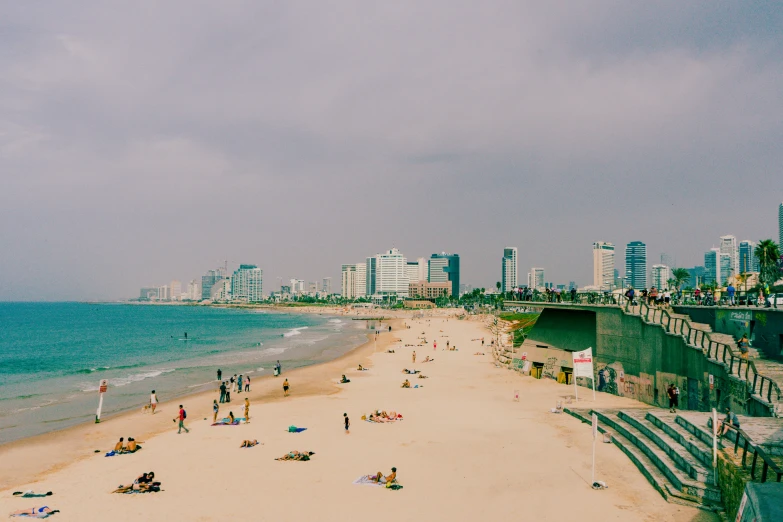 the people are walking on the beach near the water