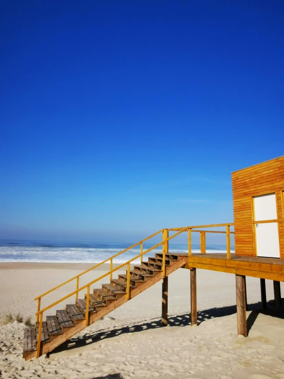 the stairway to a beach side deck with steps leading up to the water