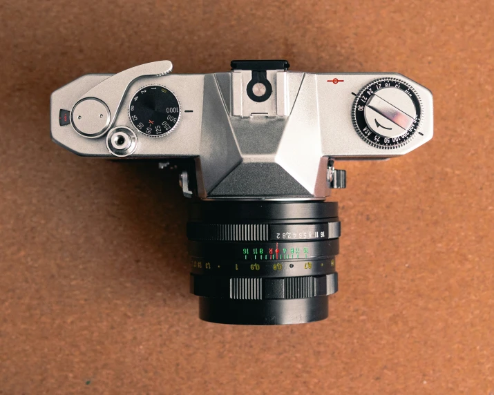 a white analog camera mounted on a brown background