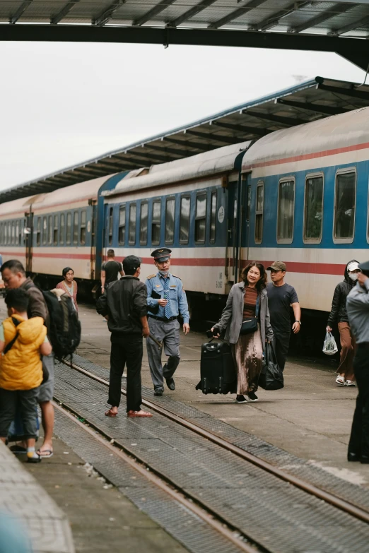 a large group of people standing by a train