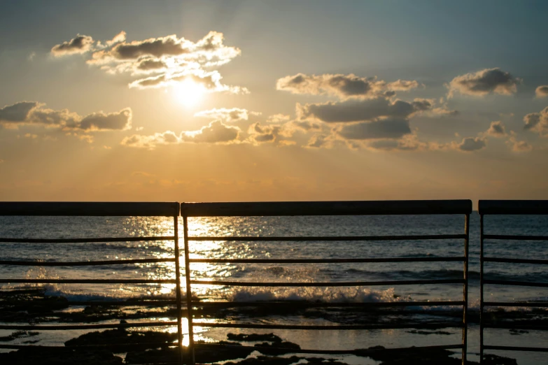 the sun is setting over a lake on a beach