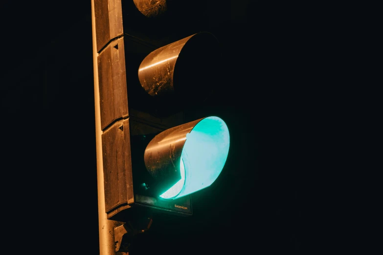 a green stop light with blue light at the top
