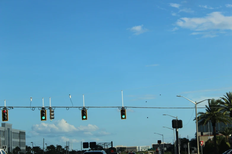 a traffic light is in the air as the vehicles go down the road