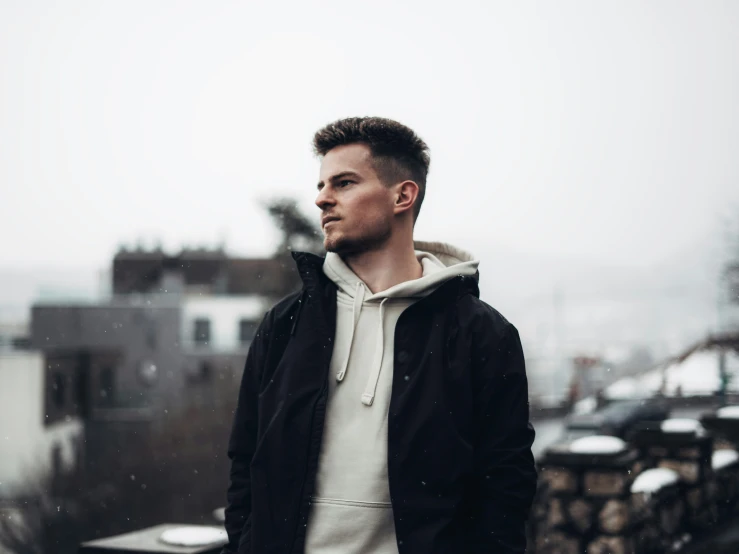 a man looking out over a rooftop in the snow