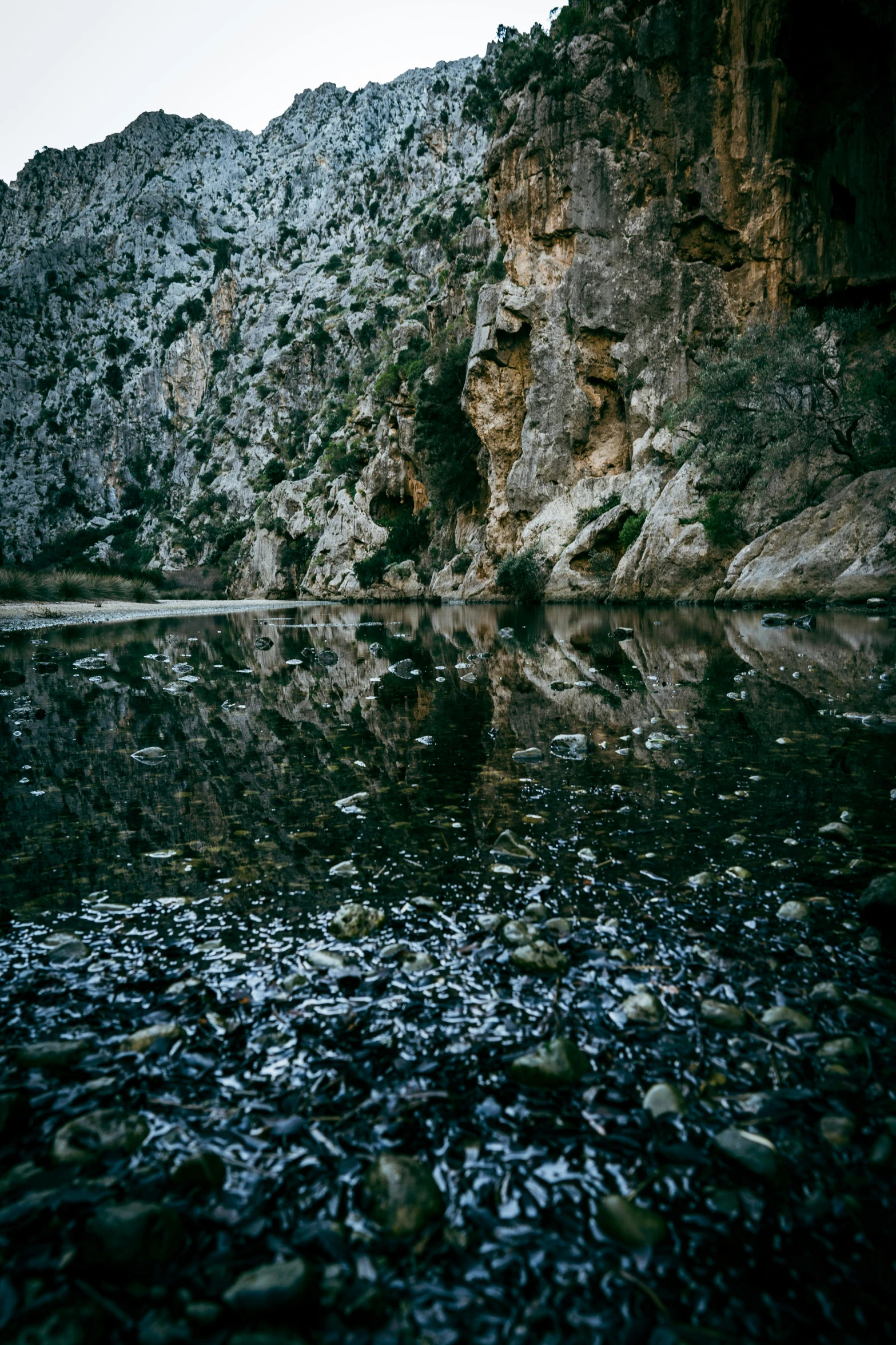 a large body of water sitting next to a rocky cliff