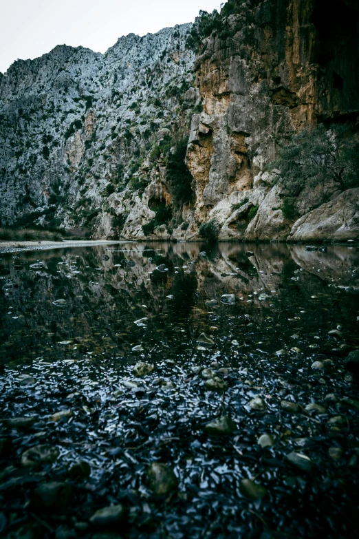 a large body of water sitting next to a rocky cliff