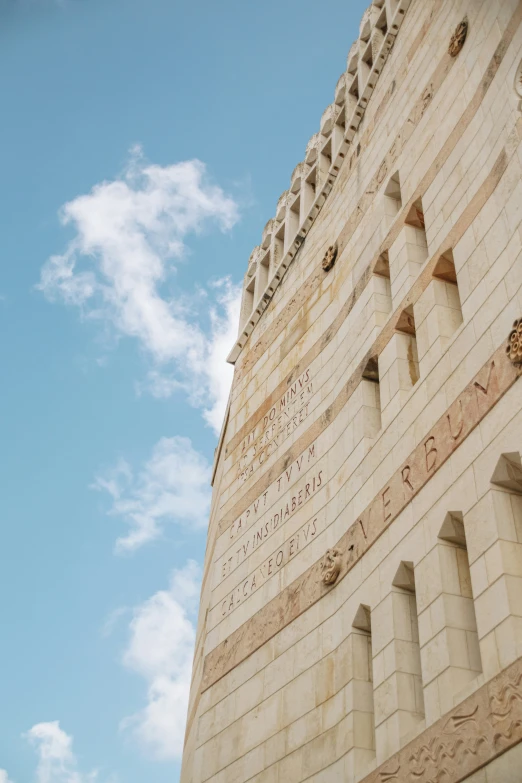 an ancient building under a blue sky and clouds