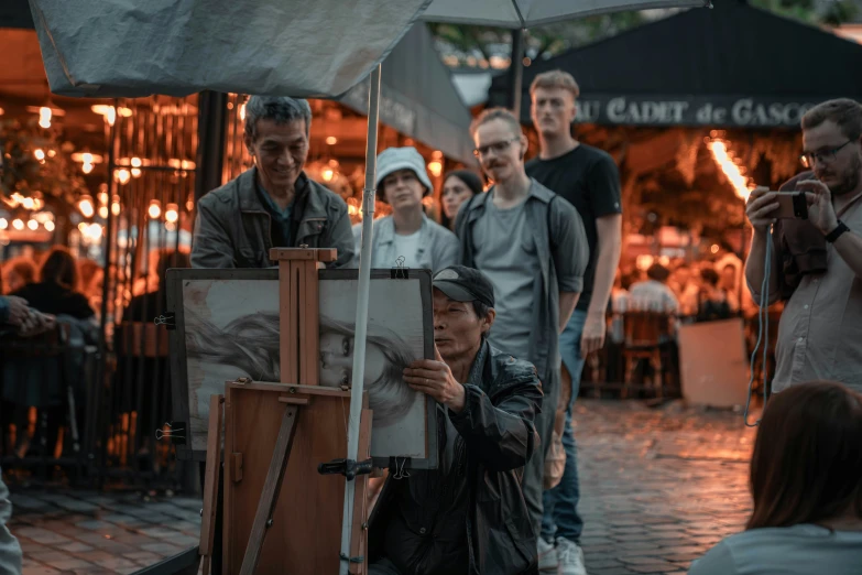 group of people holding a painting and posing for a picture