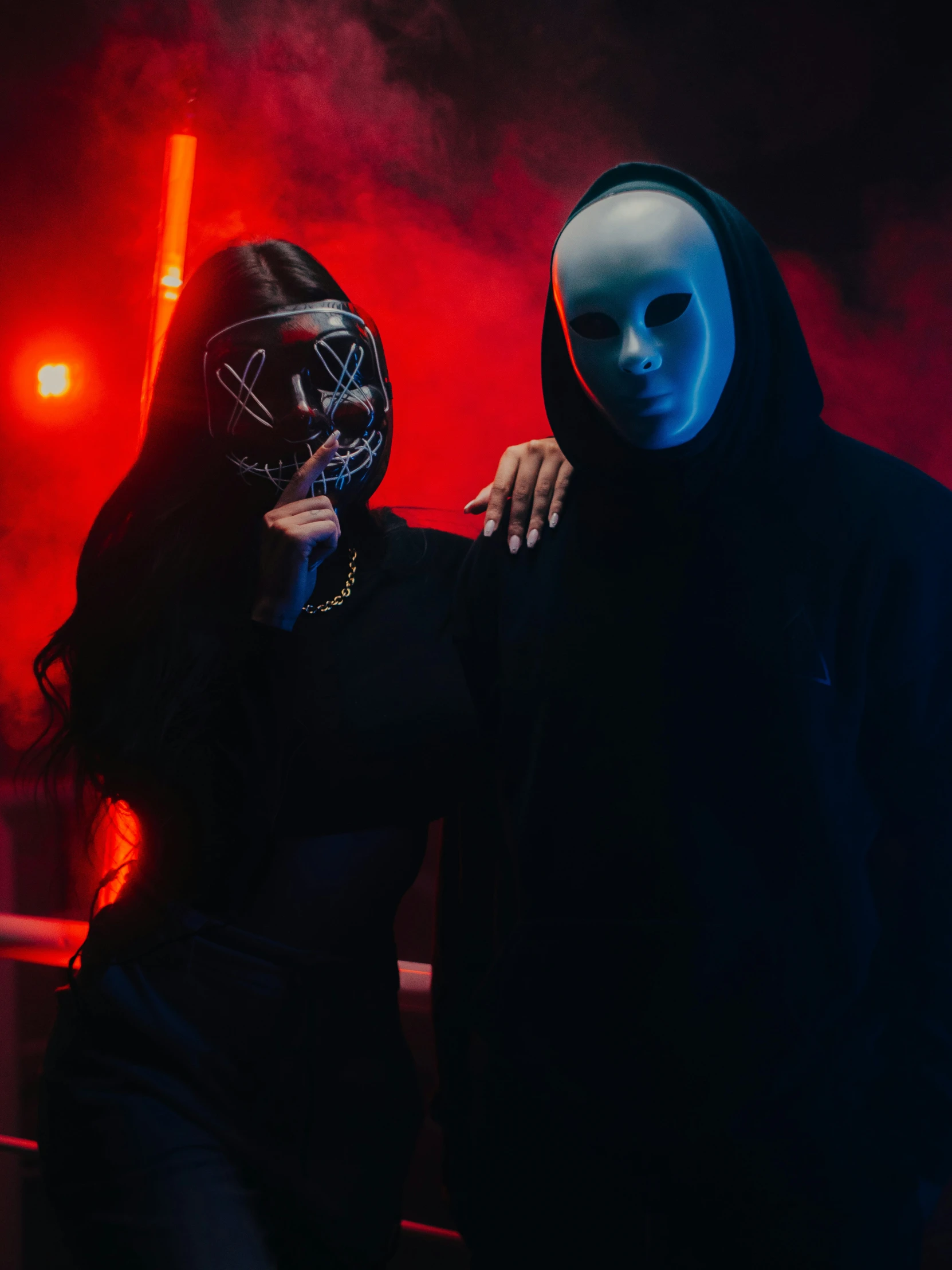 a man and woman wearing masks stand side by side