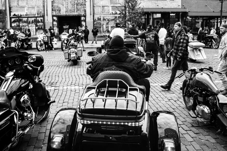 many people walking down the street with motorcycles