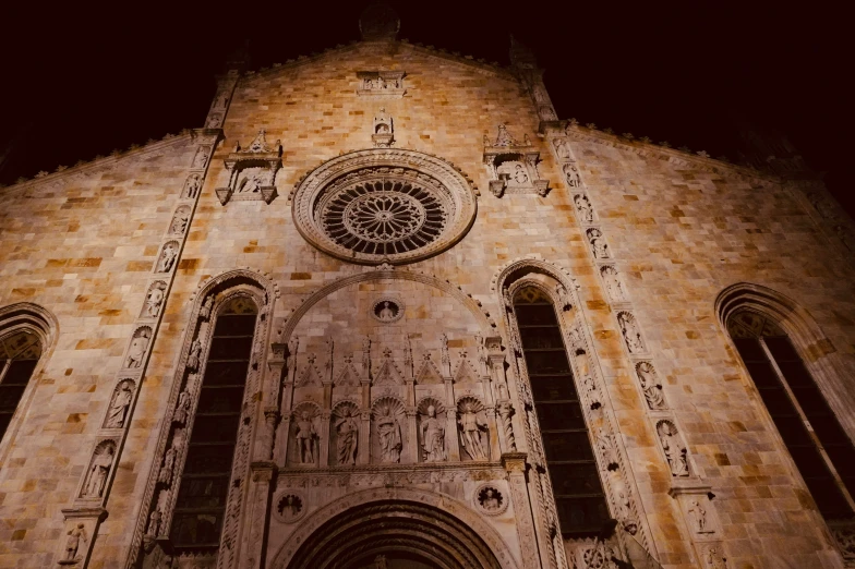 an old cathedral tower is lit up at night