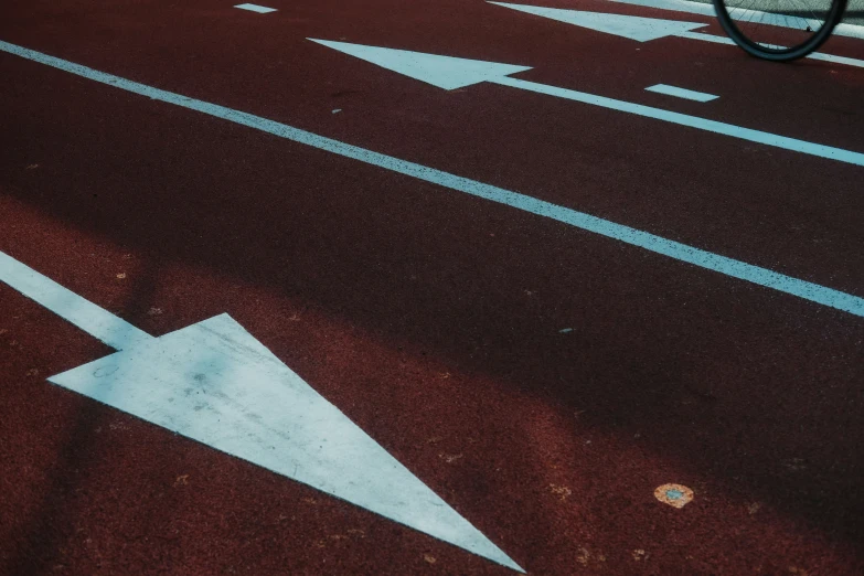 a white arrow is painted on the asphalt in a lot