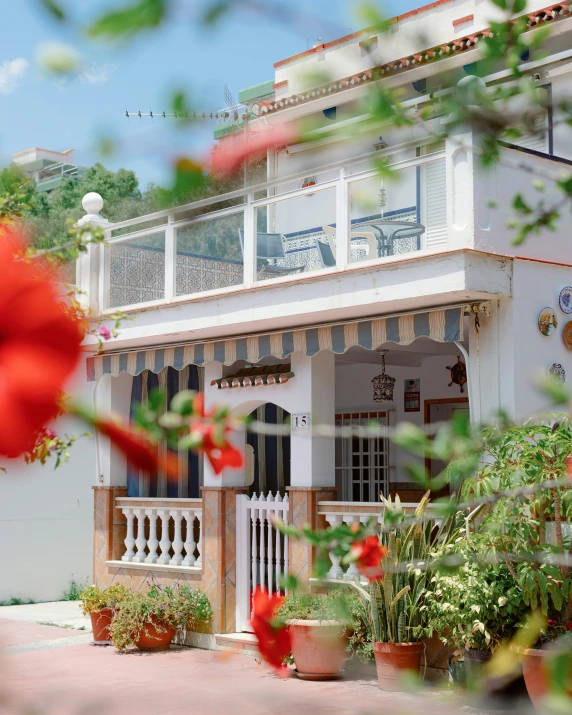 a white home with pots of red flowers