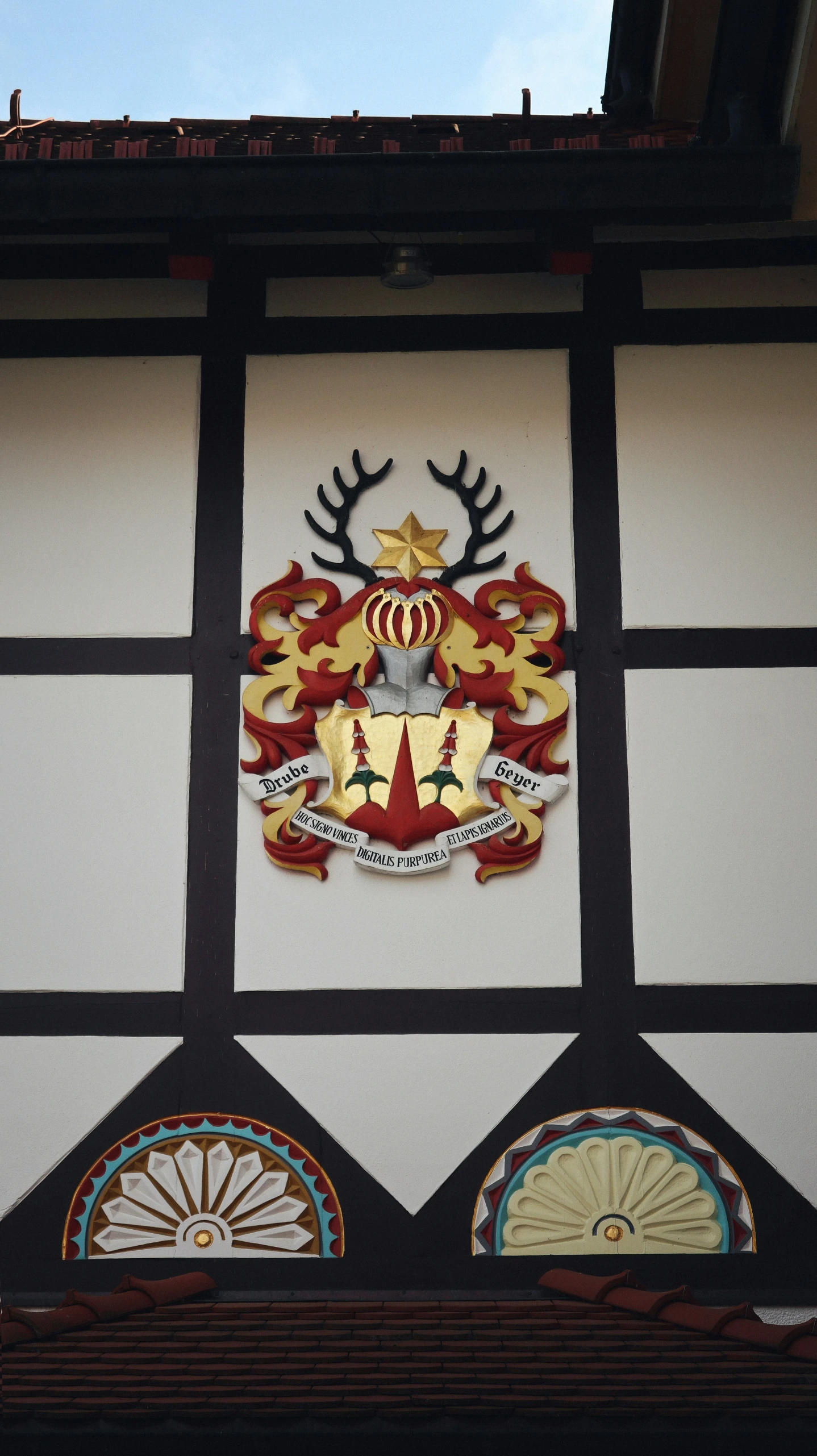 a coat of arms on a building with a blue sky background