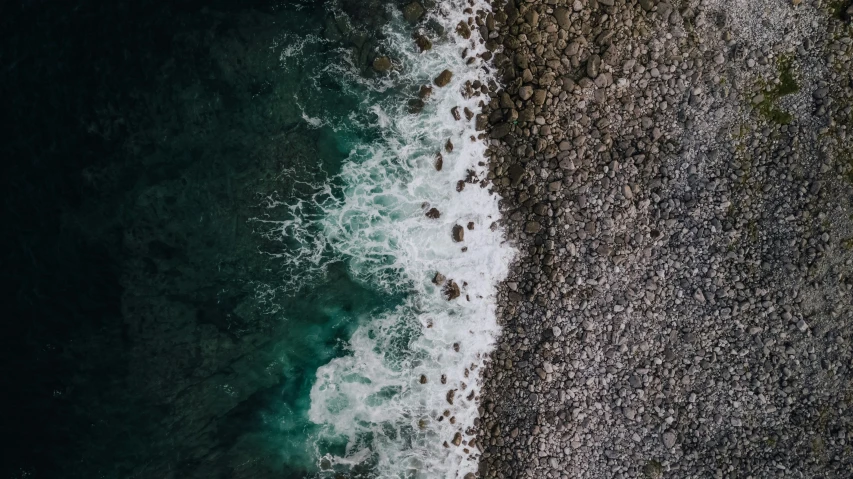 a view of the shoreline of the ocean and shore with the waves crashing on the rocks