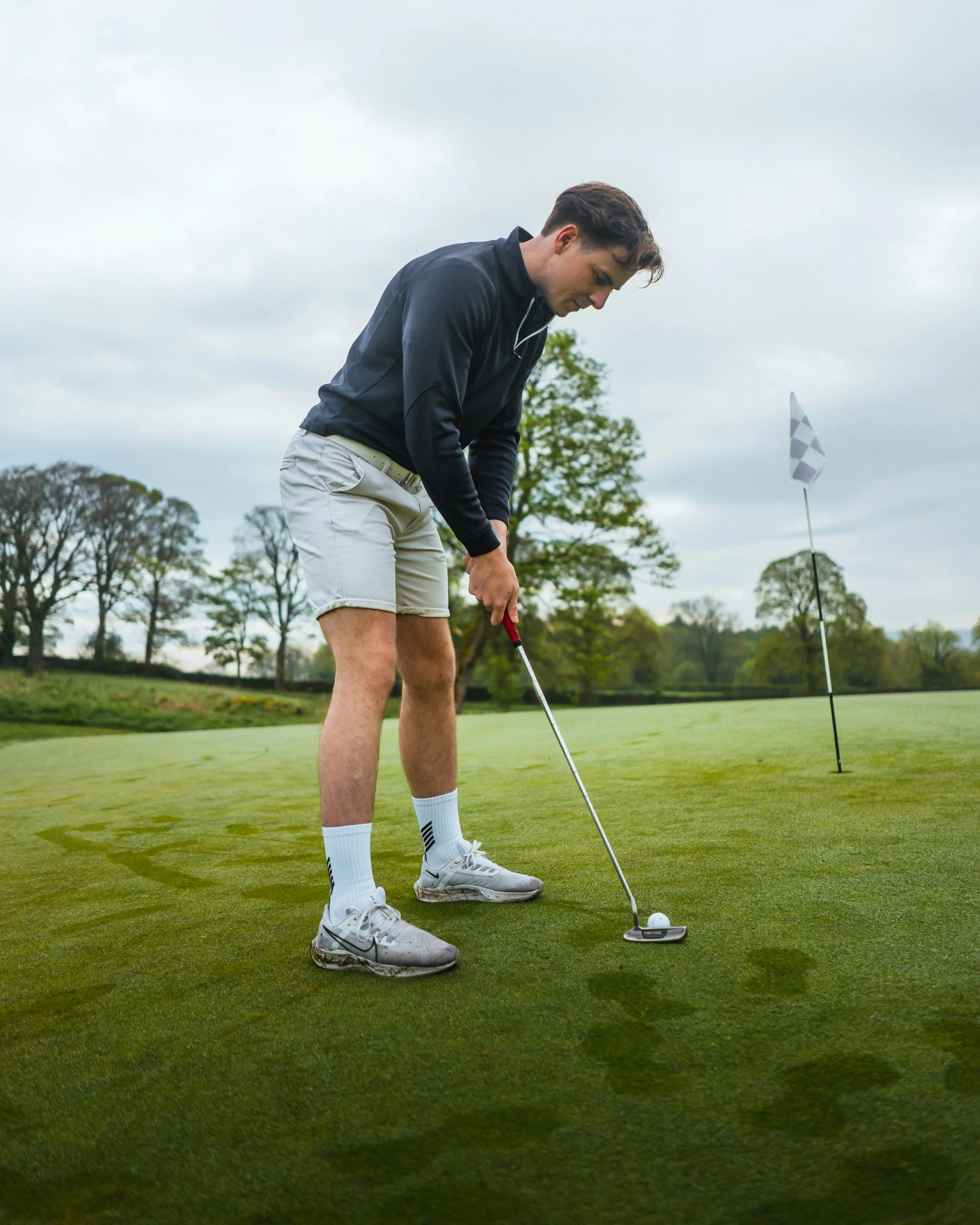 a young man putting putt putts on a golf green