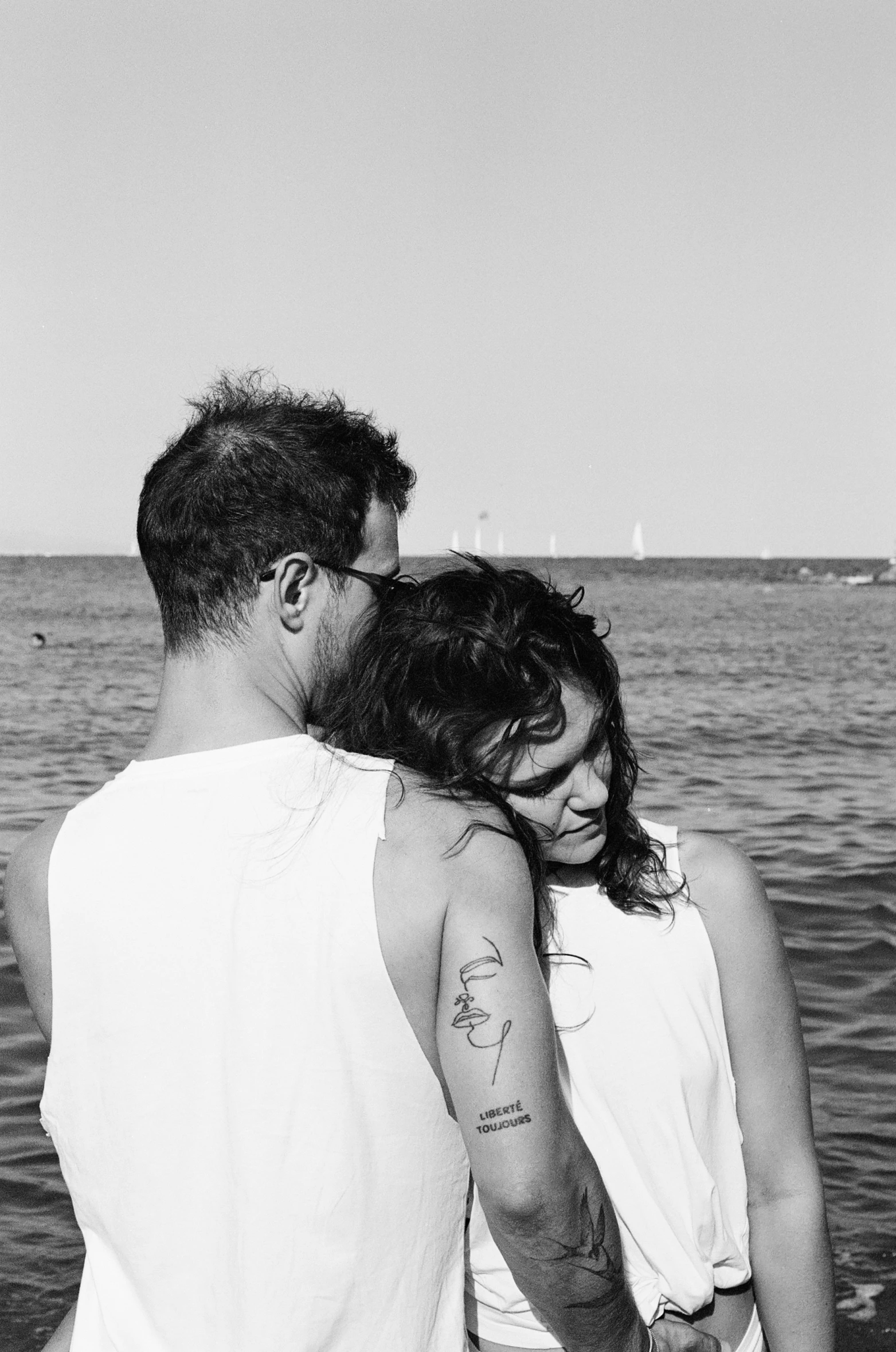 a couple are cuddling on the beach