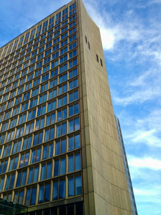 a tall brown building on top of a blue sky