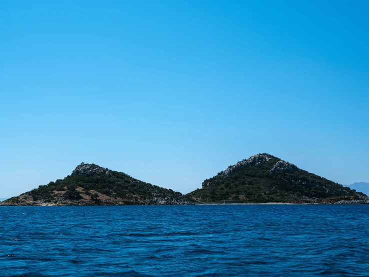 a few small island surrounded by blue water