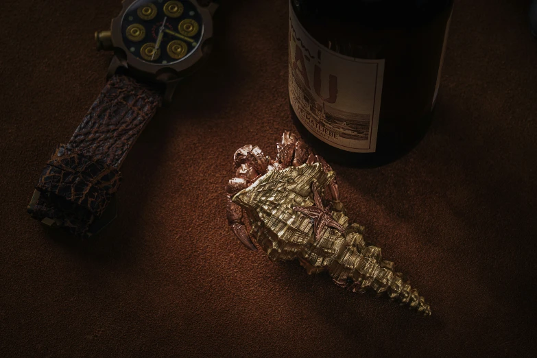 a bottle and some jewelry next to a watch