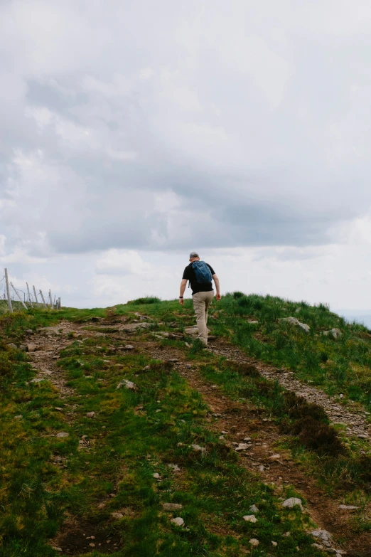 a person walking up the side of a hill towards the ocean