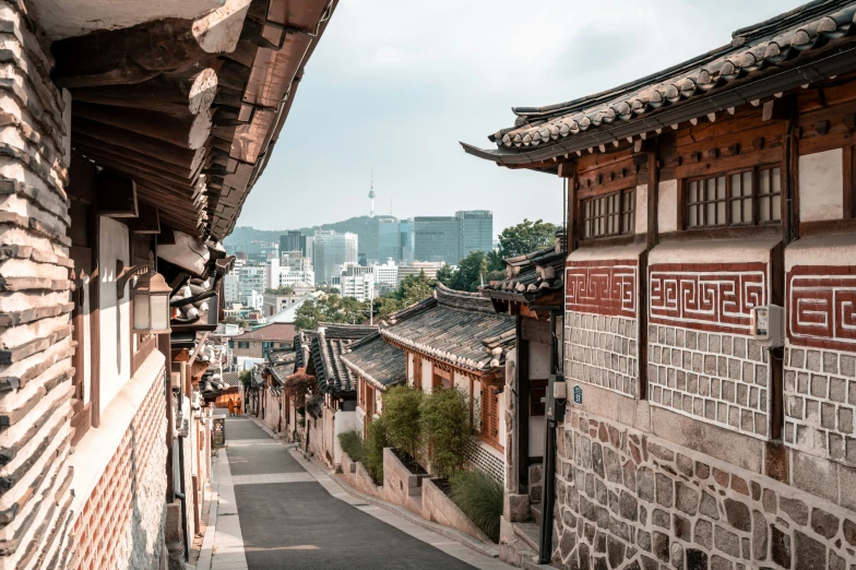 a narrow road leads to several buildings with tall buildings