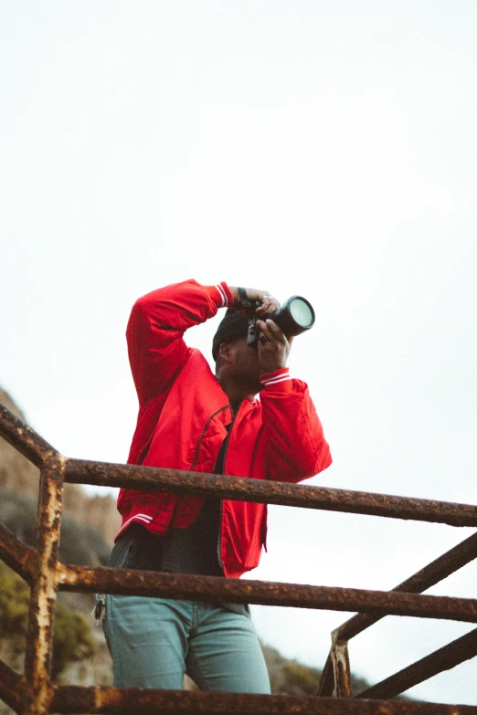 a man in a red jacket looking into a telescope