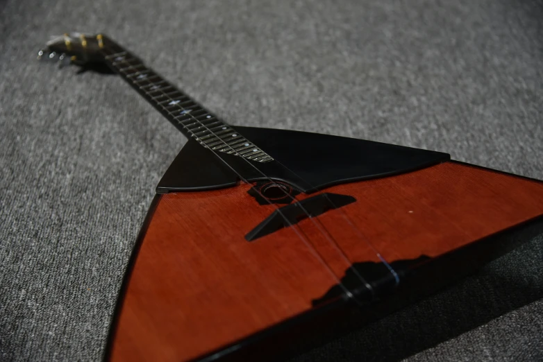 a wooden guitar resting on a grey surface