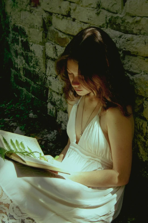 a woman in a dress is reading a book