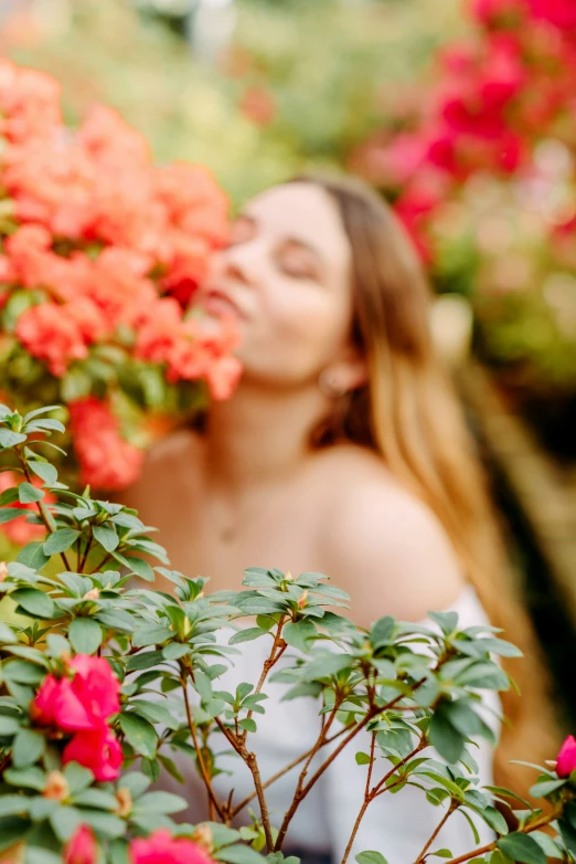 a woman in white and red flowers behind a fence