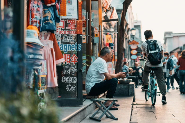 people walking and sitting on benches in the city