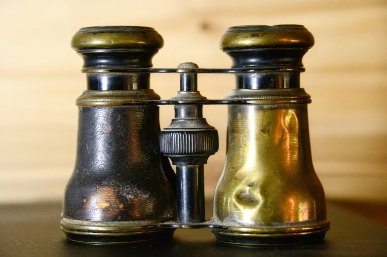 two ss and silver binoculars on the table