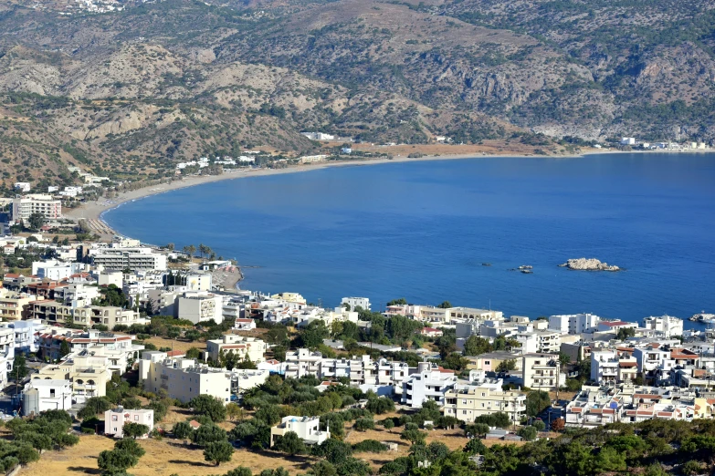 a lake and some buildings with mountains in the background