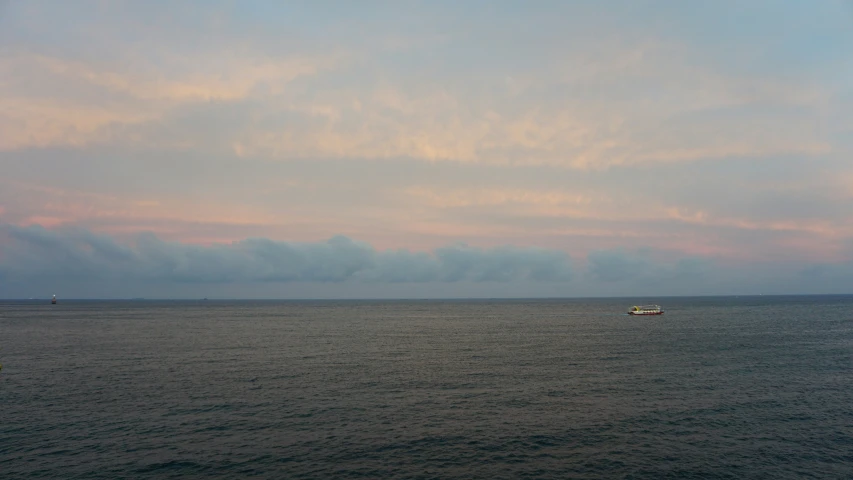 a boat is out on the ocean with sky in background