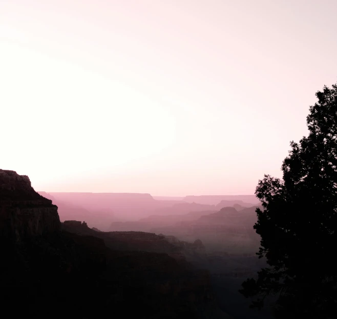 the view from a canyon, silhouetted by the sun at dusk