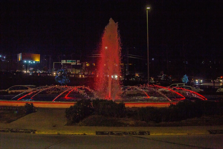 illuminated fountain in the middle of an area with lights and decorations