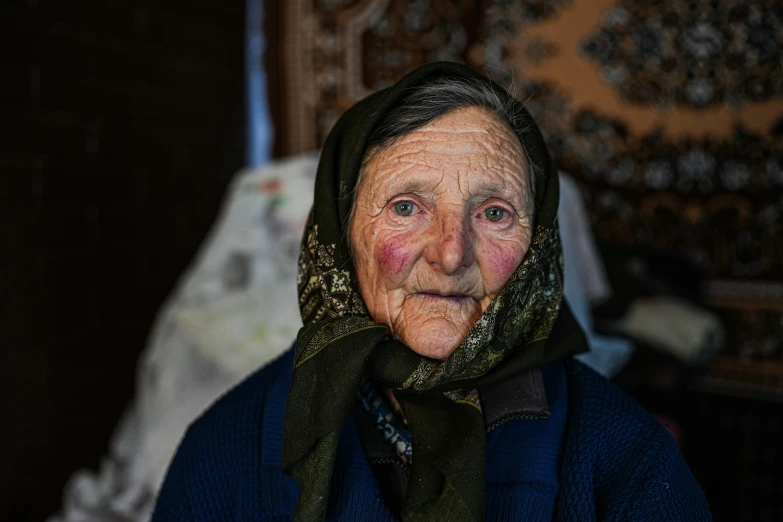 an older woman poses for a po in her head scarf