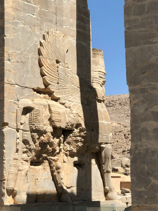 large ancient stone statue sitting between two very tall buildings