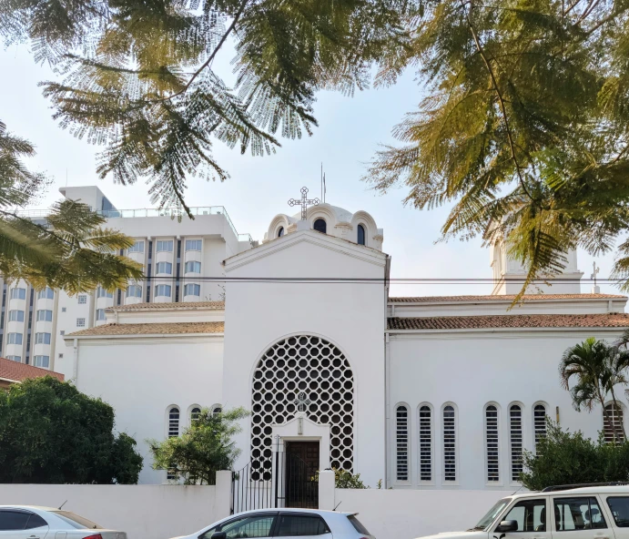 several white cars parked outside a church with two large windows