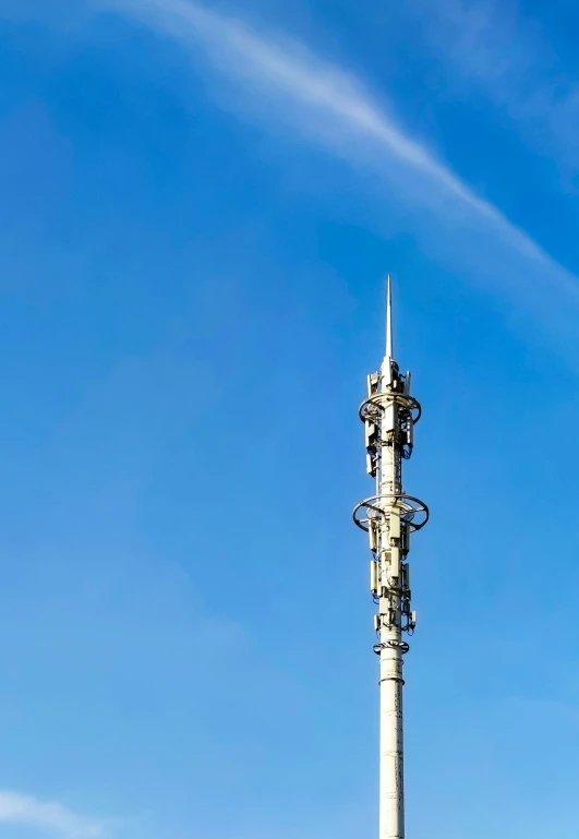 there is a tall white tower with a weather vane