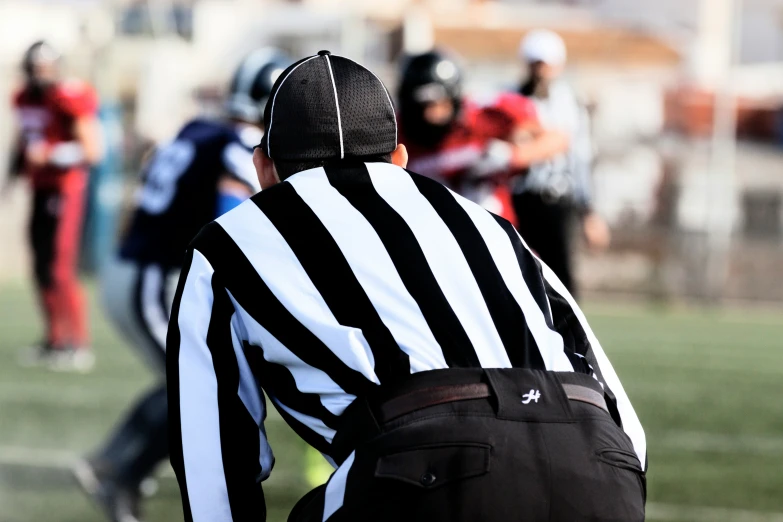 a referee with a black and white striped jacket