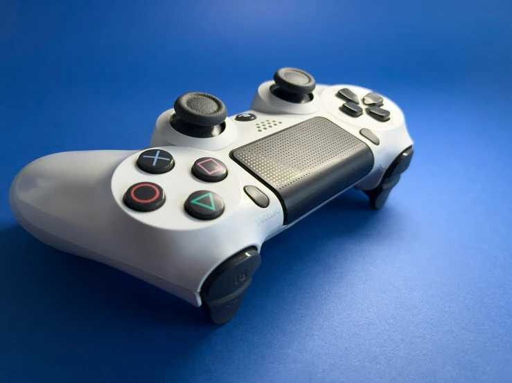 a black and white controller on top of a blue surface