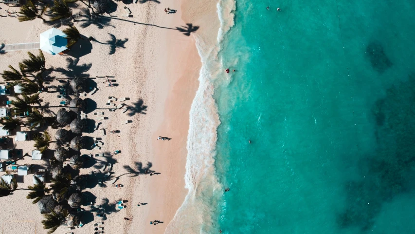 an aerial view of people in the ocean at a tropical resort