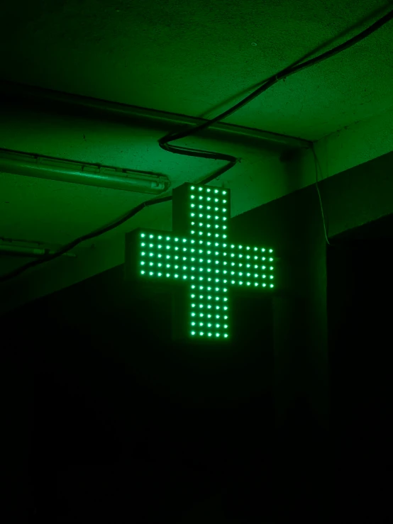 a large green lighted cross on a building