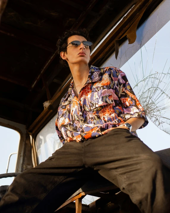 man in shirt and jeans sitting on wooden bench